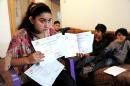 Leonarda Dibrani (15) shows her French language certificates at her home in the town of Mitrovica on October 16, 2013