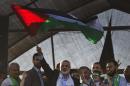 Hamas top leader in the Gaza Strip Ismail Haniya (C) waves the Palestinian national flag during a rally in Gaza City on August 27, 2014