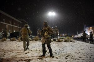 Snow falls as Missouri National Guard stand outside …