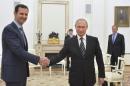 Russian President Putin shakes hands with Syrian President Assad during a meeting at the Kremlin in Moscow