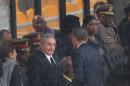 US President Barack Obama shakes hands with Cuban President Raul Castro at the FNB Stadium in Soweto, South Africa, in the rain for a memorial service for former South African President Nelson Mandela, Tuesday Dec. 10, 2013. The handshake between the leaders of the two Cold War enemies came during a ceremony that's focused on Mandela's legacy of reconciliation. Hundreds of foreign dignitaries and world heads of states gather Tuesday with thousands of South African people to celebrate the life, and mark the death, of Nelson Mandela who has became a global symbol of reconciliation. (AP Photo) SOUTH AFRICA OUT
