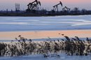 CORRECTS TO RANKS BEHIND, NOT RANKS SECOND - In this photo taken Friday March 16, 2012 and made available March 26, 2012, oil rigs belonging to PetroChina are seen near the banks of a snow covered lake in Daqing in northeastern China's Heilongjiang province. A big shift is happening in Big Oil: an American giant now ranks behind a Chinese upstart. Exxon Mobil is pumping less oil than PetroChina, a company formed just 13 years ago by the Chinese government to better compete for the world's oil and natural gas. On March 29, 2012, the shift is expected to become official when the Beijing company announces that it produced more crude last year than its 130-year-old Texas rival. (AP Photo) CHINA OUT
