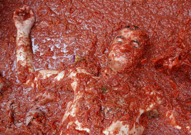 A reveler lays in tomato pulp during the annual "Tomatina" tomato fight fiesta in the village of Bunol, near Valencia, Spain, Wednesday, Aug. 31, 2011. Bunol's town hall estimated more than 40,000 peo