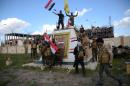 Shiite fighters from the Popular Mobilisation units celebrate in front of the the provincial council building inside the northern Iraqi city of Tikrit on March 31, 2015 during a military operation to retake it from IS