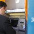 A man withdraws money from an ATM at a branch of Bank of Cyprus in Bucharest