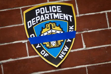 An NYPD logo is pictured on a wall above a makeshift memorial at the site where two police officers were shot in the head in the Brooklyn borough of...