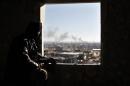 File photo of Free Syria Army fighter watching from his position as smoke during a fight with forces loyal to President Bashar al Assad at the front line in Aleppo