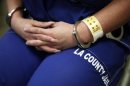 Woman sits handcuffed after arriving at the Los Angeles County women's jail in Lynwood