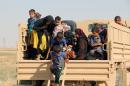 Iraqi displaced families step down from a truck upon their arrival in an area controlled by the Peshmerga forces, some 55 kilometres west of Iraqi city of Kirkuk, on August 21, 2016