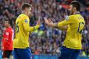 Arsenal's Welsh midfielder Aaron Ramsey (L) refuses to celebrate with French striker Olivier Giroud after scoring the opening goal against his former club Cardiff City during their English Premier League football match in Cardiff on November 30, 2013