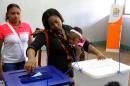 A mother casts her vote for Mozambique's local elections in Maputo on November 20, 2013
