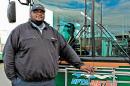 In an Oct. 28, 2013, photo provided by the Niagara Frontier Transportation Authority, NFTA bus driver Darnell Barton poses in front of a bus in Buffalo, N.Y. On Oct. 18, 2103, Barton's decisive action stopped a woman from leaping from a roadway bridge to her death on to the highway below. Caught between the rules of his job and his training as a first responder, Barton stopped his bus, grabbed the woman and brought her back over the rail to safety. (AP Photo/Niagara Frontier Transportation Authority, Doug Hartmayer)