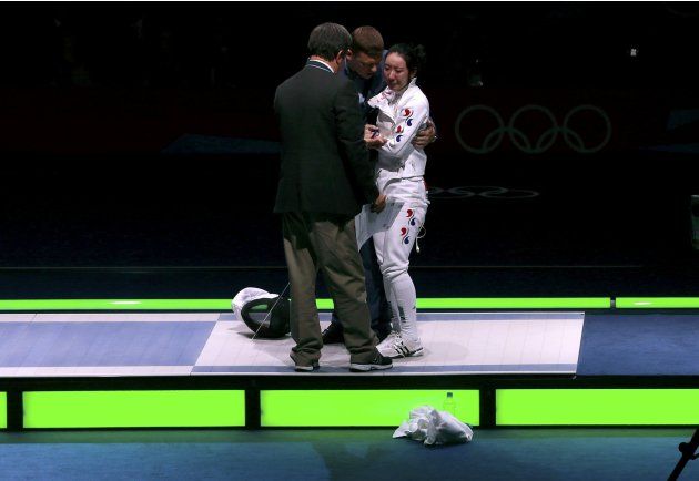South Korea's Shin reacts as she is escorted after being defeated by Germany's Heidemann during their women's epee individual semifinal fencing competition at the ExCel venue at the London 2012 Olympi