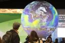 People watch the Earth globe at the COP21 climate summet in Paris on December 10, 2015