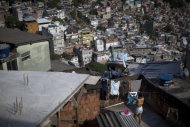 In this photo taken April 11, 2012, a woman hangs clothes at her home in Rocinha slum in Rio de Janeiro, Brazil. Setbacks in a security program meant to take back territory from the drug trade have shown the immense challenge of pacifying the city’s violent slums and raised questions about the state's ability to keep the peace as Rio prepares to take the world stage not just for the Olympics but the 2014 World Cup, which will host its headline events in Rio. (AP Photo/Felipe Dana)