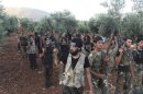 Free Syrian Army fighters, holding their weapons, stand during military training north of Idlib