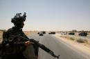 A member of the Iraqi security forces keeps watch on August 14, 2014 on the main highway near Ramadi