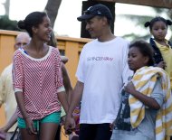 President Barack Obama holds hands with his daughters Malia, left, and Sasha, right, as they leave Sea Life Park, a marine wildlife park, with family friends, Tuesday, Dec. 27, 2011, in Waimanalo, Hawaii. (AP Photo/Carolyn Kaster)