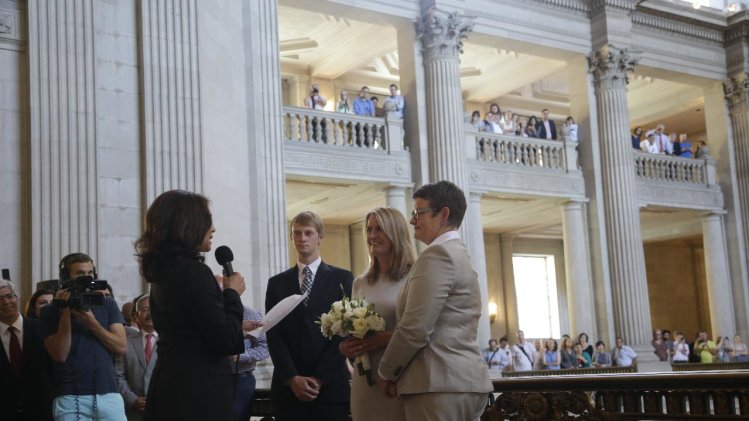 Sandy Stier, center left, and Kris Perry, at right, exchange wedding vows in front of California Attorney General Kamala Harris, left, at City Hall in San Francisco, Friday, June 28, 2013. Stier and Perry, the lead plaintiffs in the U.S. Supreme Court case that overturned California's same-sex marriage ban, tied the knot about an hour after a federal appeals court freed same-sex couples to obtain marriage licenses for the first time in 4 1/2 years. (AP Photo/Marcio Jose Sanchez)