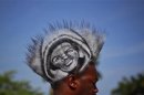A man sports an image of black teenager Trayvon Martin on his hair during a rally to protest his killing in Miami