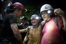 A rescued miner, center, is greeted by another miner while being helped by a rescue worker as he leaves the El Comal gold and silver mine in Bonanza, Nicaragua, Friday, Aug. 29, 2014. The first 11 of 24 freelance gold miners trapped by a collapse in a mine have been rescued and crews were working early Saturday to free more, officials said. (AP Photo/Esteban Felix)
