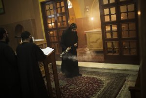 A priest purifies the church with incense during prayer …