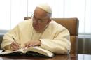 Pope Francis signs a guest book as he meets with United Nations Secretary Ban Ki-moon at the United Nations headquarters, Friday, Sept. 25, 2015. (Joshua Lott/Pool Photo via AP)