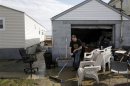 Mike Starkie sweeps mud out of his garage as he cleans up from Hurricane Sandy in Fairhaven