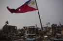 A flag of the Philippines flies over a destroyed neighborhood in Tacloban, Philippines on Friday Nov. 22, 2013. Hundreds of thousands of people were displaced by Typhoon Haiyan, which tore across several islands in the eastern Philippines on Nov. 8. (AP Photo/David Guttenfelder)