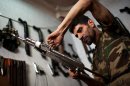 Abu Mohammad, 39, checks an AK47 at his gun shop in the Fardos district of Syria's northern city of Aleppo on September 21, 2013