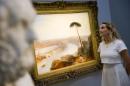 A gallery assistant studies a painting by artist Joseph Mallord William (JMW) Turner entitled "Rome, from Mount Aventine" at Sotheby's auction house in London, on November 28, 2014
