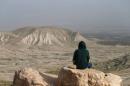 Palestinian man sits on a rock at Jordan Valley near the West Bank city of Jericho