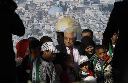 Palestinian President Mahmoud Abbas, center, is surrounded by children during celebrations for the successful bid to win U.N. statehood recognition for Palestine in the West Bank city of Ramallah, Sunday, Dec. 2, 2012. Abbas has returned home to a hero's welcome after winning a resounding endorsement for Palestinian independence at the United Nations. Israel on Sunday roundly rejected the United Nations' endorsement of an independent state of Palestine, announcing it would withhold more than $100 million collected for the Palestinian government to pay debts to Israeli companies and earlier said it would start drawing up plans to build thousands of settlement homes. (AP Photo/Nasser Shiyoukhi)
