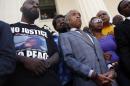 Civil rights leader Rev. Al Sharpton, center, stands with the parents of Michael Brown, Lesley McSpadden, right, and Michael Brown Sr., left, during a news conference outside the Old Courthouse Tuesday, Aug. 12, 2014, in St. Louis. Brown Jr., 18, who was unarmed, was shot to death Saturday by a Ferguson police officer while walking with a friend down the center of the street. (AP Photo/Jeff Roberson)