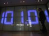 Employee of foreign exchange company walks past a monitor displaying the Japanese yen's exchange rate against the U.S. dollar in Tokyo