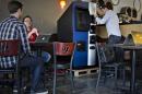 Vancouver Bitcoiniacs Trading Company co-founder Demeter prepares, according to him, the first bitcoin ATM machine in a Waves Coffee House in Vancouver