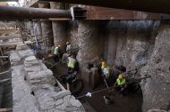 Workers of Metro's construction company are seen at the ancient ruins in the northern Greek port city of Thessaloniki on Monday, June 25, 2012. Archaeologists in Greece’s second largest city have uncovered a 70-meter (230-foot) section of an ancient road built by the Romans that was city’s main travel artery nearly 2,000 years ago. The marble-paved road was unearthed during excavations for the city’s new subway system that is due to be completed in four years, and will be raised to be put on permanent display for passengers when the metro opens. (AP Photo/Nikolas Giakoumidis)