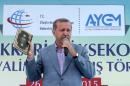 Turkey President Recep Tayyip Erdogan holds a Koran as he speaks during the opening ceremony for the Selahaddin Eyyubi airport on May 26, 2015, in Hakkari province