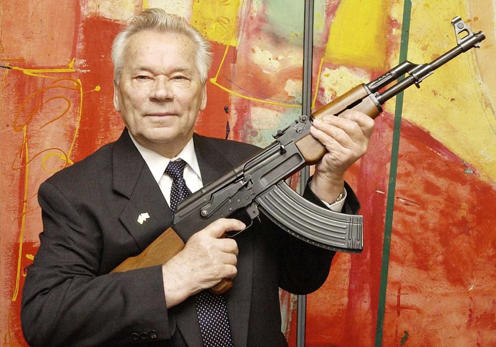 In this July 26, 2002 file photo, Russian weapon designer Mikhail Kalashnikov presents his legendary assault rifle to the media while opening the exhibition "Kalashnikov - legend and curse of a weapon" at a weapons museum in Suhl, Germany. Mikhail Kalashnikov, whose work as a weapons designer for the Soviet Union is immortalized in the name of the world&rsquo;s most popular firearm, has died at the age of 94, Monday Dec. 23, 2013. (AP Photo/Jens Meyer, File)