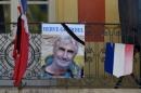 A portrait of mountain guide Frenchman Gourdel hangs near a French flag outside the town hall in Saint-Martin-Vesubie
