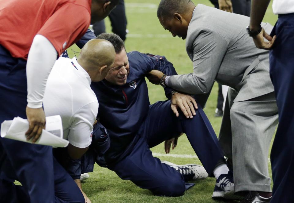 Houston Texans head coach Gary Kubiak, center, his helped after he collapsed on the field during the second quarter of an NFL football game against the Indianapolis Colts, Sunday, Nov. 3, 2013, in Houston. (AP Photo/David J. Phillip)