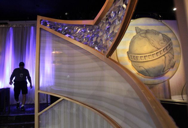 In this Thursday, Jan. 12, 2012 photo, a man walks near the Golden Globe in the ballroom at the Beverly Hilton Hotel in Beverly Hills, Calif., as workers prepare for the 69th Annual Golden Globe Awards on Sunday. (AP Photo/Jae C. Hong)