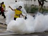 A protester throws a tear gas canister back at police in Kuala Lumpur, Malaysia, Saturday, April 28, 2012. Malaysian police fired tear gas and chemical-laced water Saturday at thousands of demonstrators demanding an overhaul in electoral policies that they call biased ahead of national polls expected soon.At least 25,000 demonstrators had swamped Malaysia's largest city in one of the Southeast Asian nation's biggest street rallies in the past decade. (AP Photo/Mark Baker)