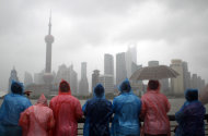 Tourists in colorful rain coats visit the Bund, one of the most popular tourist destinations in town, in heavy rain and strong wind caused by Typhoon Muifa in Shanghai, China, Sunday, Aug. 7, 2011. Typhoon Muifa is forecast to hit China early Monday morning, making landfall in the eastern province of Shandong and skimming the coast as it heads north, China's Central Meteorological Administration said. (AP Photo/Eugene Hoshiko)