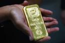 A woman holds a one-kilogram gold bar at the headquarters of the Australian Bullion Company in Sydney