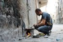 A rebel fighter cooks food on a make-shift stove in Syria's northern city of Aleppo on September 25, 2013