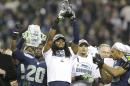 Seattle Seahawks' Richard Sherman holds up the George Halas Trophy after the NFL football NFC Championship game against the San Francisco 49ers Sunday, Jan. 19, 2014, in Seattle. The Seahawks won 23-17 to advance to Super Bowl XLVIII. (AP Photo/Elaine Thompson)