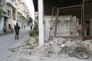 A damaged bicycle is pictured as a Free Syrian Army walks past children playing along a street in the besieged area of Homs