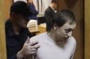Bolshoi Theatre dancer Dmitrichenko, who is on trial for ordering an acid attack on the artistic director of Russia's Bolshoi ballet Filin, is escorted out of a court room in Moscow