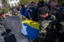 Ukrainian soldiers fold the Ukrainian flag, which was removed by a Crimean pro- Russian self-defense force at the Ukrainian Navy headquarters in Sevastopol, Crimea, Wednesday, March 19, 2014. An Associated Press photographer said several hundred militiamen took down the gate and made their way onto the base. They then raised the Russian flag on the square by the headquarters. The unarmed militia waited for an hour on the square before the move to storm the headquarters. Following the arrival of the commander of the Russian Black Sea fleet, the Crimeans took over the building. (AP Photo/Andrew Lubimov)